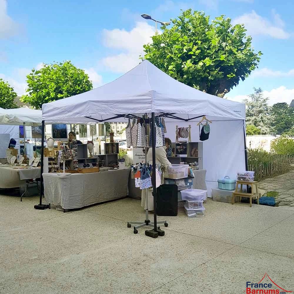 Photo d'un barnum 3x3 blanc avec un mur de la gamme Paddock sur une place