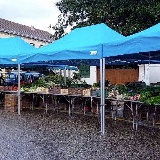 Photo d'une tente pliante 3x4,5 bleu ciel de la gamme Alu Pro 55 Luxe lors d'un marché