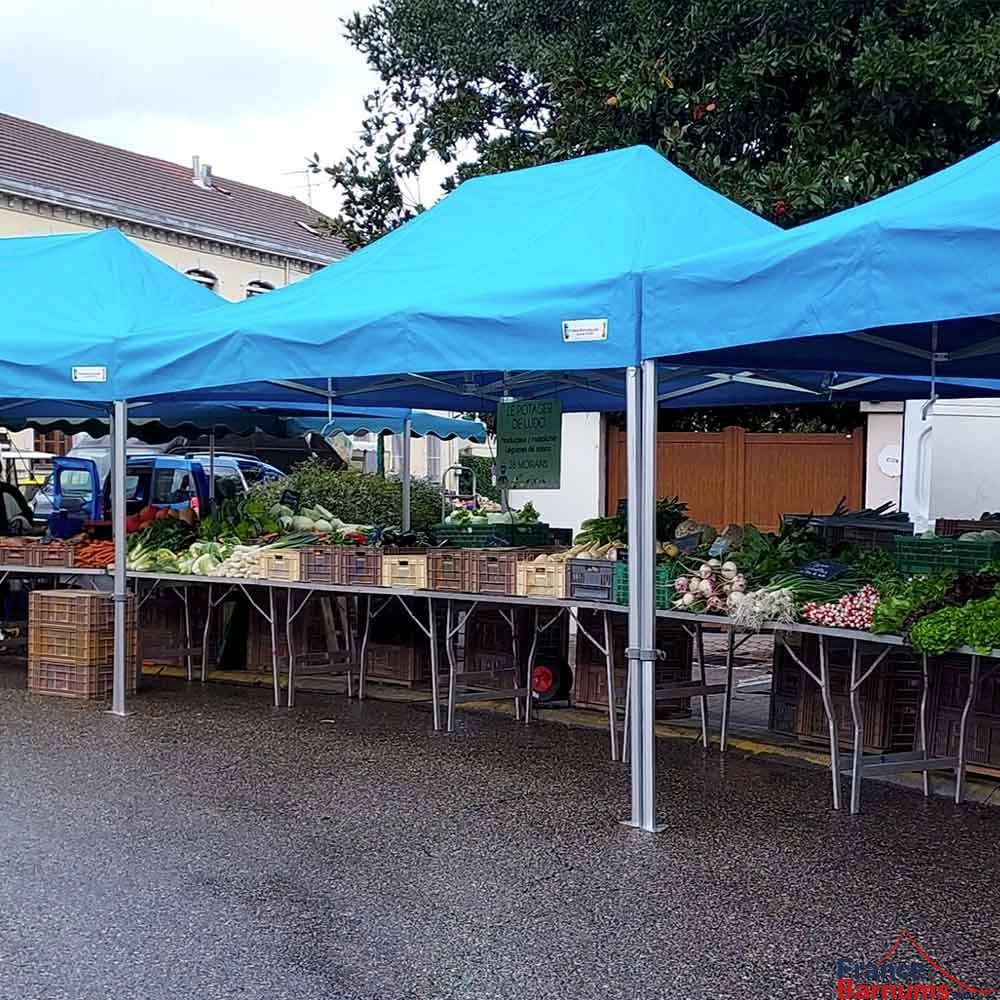 Photo d'une tente pliante 3x4,5 bleu ciel de la gamme Alu Pro 55 Luxe lors d'un marché
