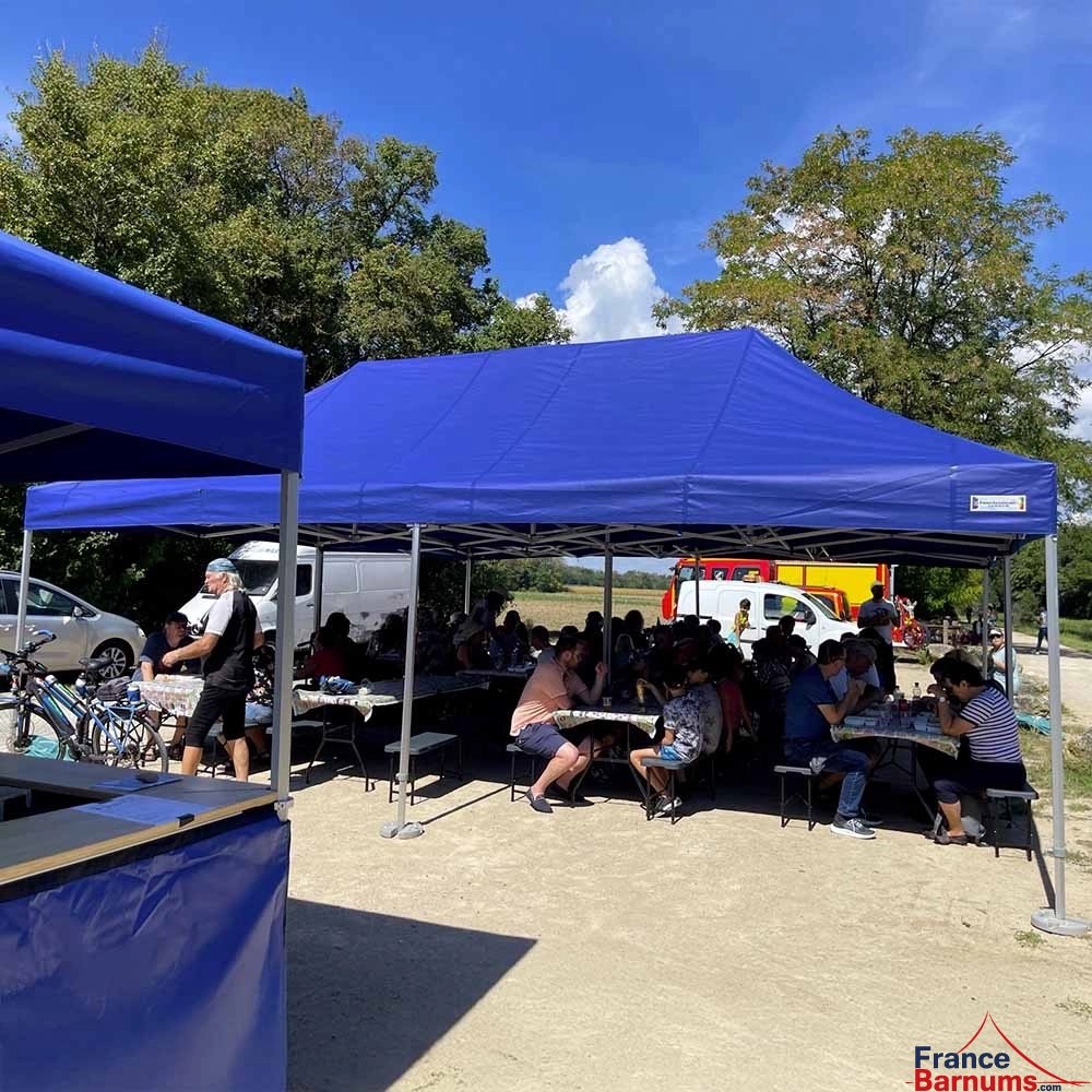 Photo d'un barnum pliant 4x8 bleu de la gamme Alu Pro 55 Luxe utilisé en stand de restauration Photo d'un barnum pliant 4x8 bleu de la gamme Alu Pro 55 Luxe utilisé en stand de restauration