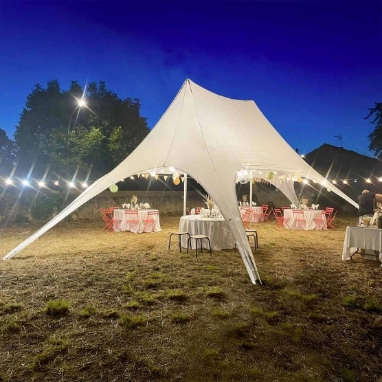 Tente étoile blanche de deux mâts lors d'une fête