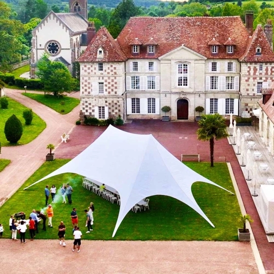 Tente étoile blanche de deux mâts lors d'une réception Tente étoile blanche de deux mâts lors d'une réception