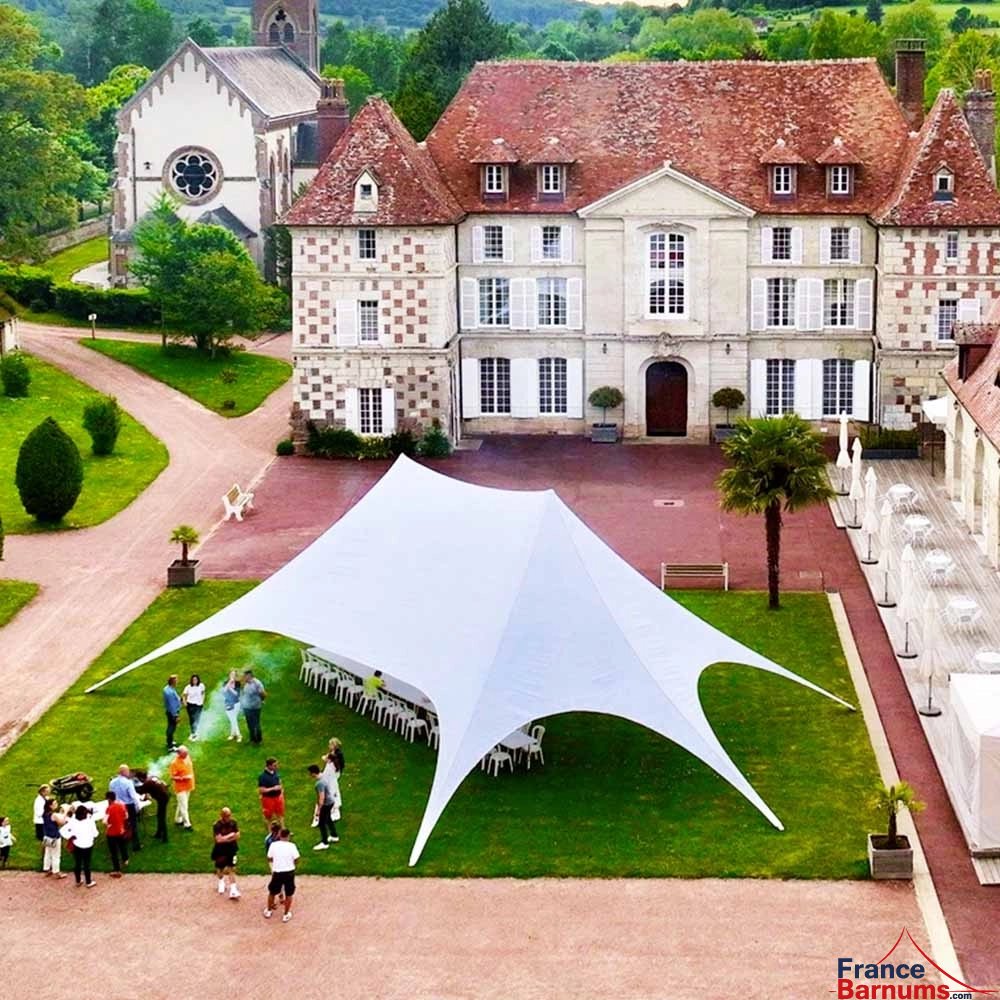Tente étoile blanche de deux mâts lors d'une réception Tente étoile blanche de deux mâts lors d'une réception
