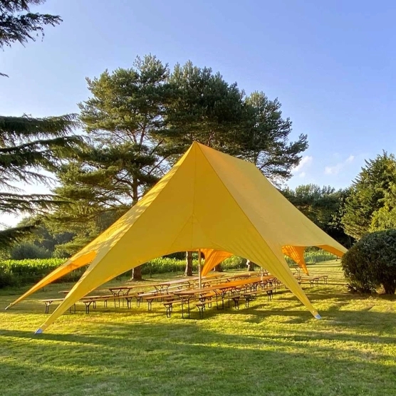 Tente étoile jaune de deux mâts lors d'une réception Tente étoile jaune de deux mâts lors d'une réception